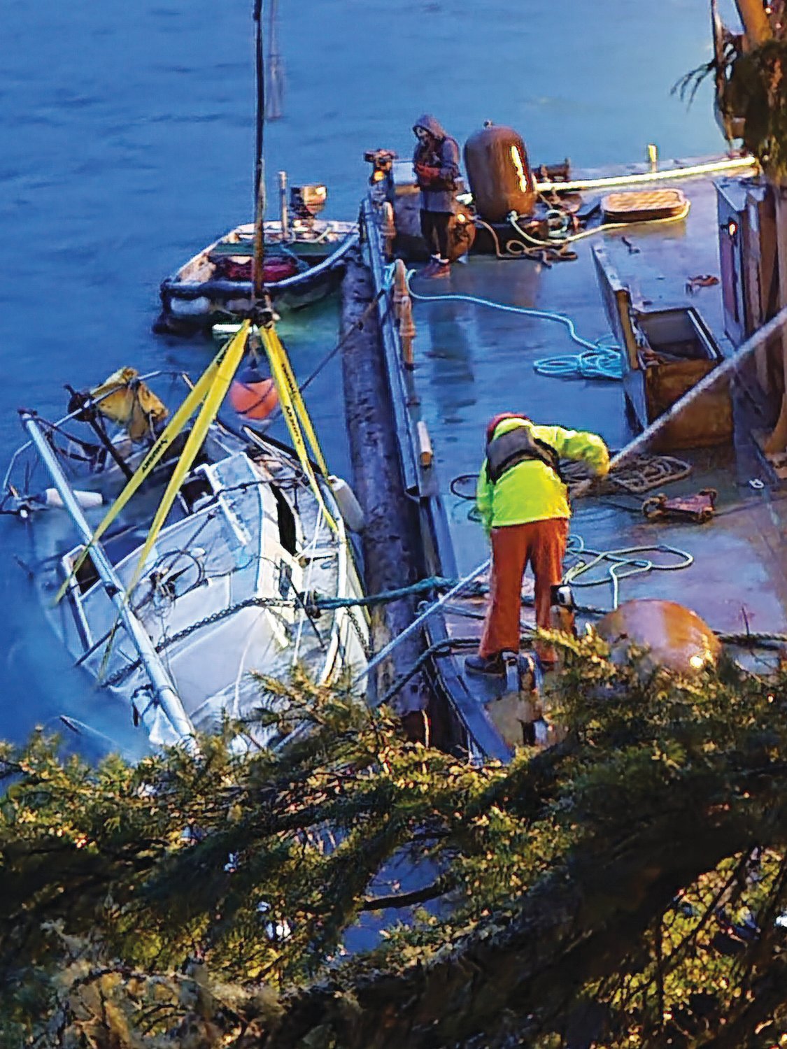 A salvage team works to remove a sunken 27-foot sailboat from Portage Canal near the Indian Island Bridge.